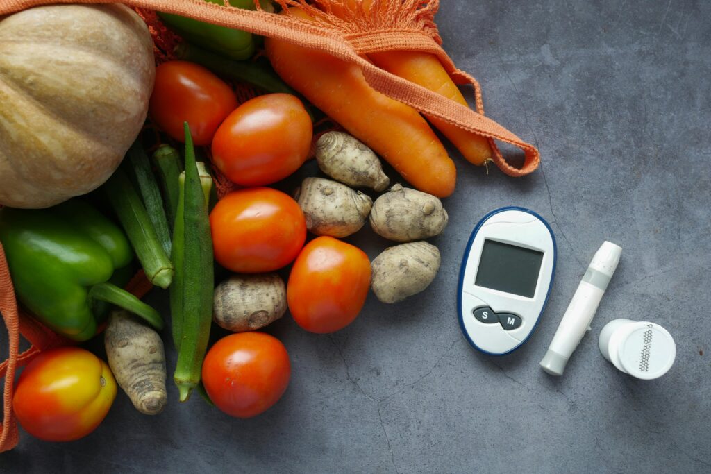 A flat lay of diabetes equipment alongside fresh vegetables promoting healthy lifestyle.